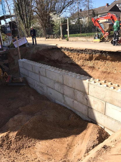 Stützmauer aus Beton Legosteinen sichert eine Böschung auf der Baustelle