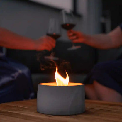 Helle Dauerfeuer Kerze von Manubeton im Außenbereich, mit Flamme und windgeschütztem Design, ideal für Outdoor-Dekoration.