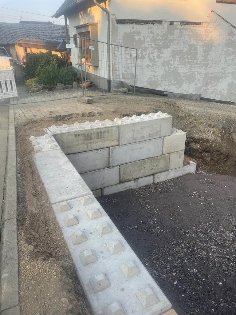Niedrige Trennwand aus Beton Legosteinen auf einem Betriebsgelände