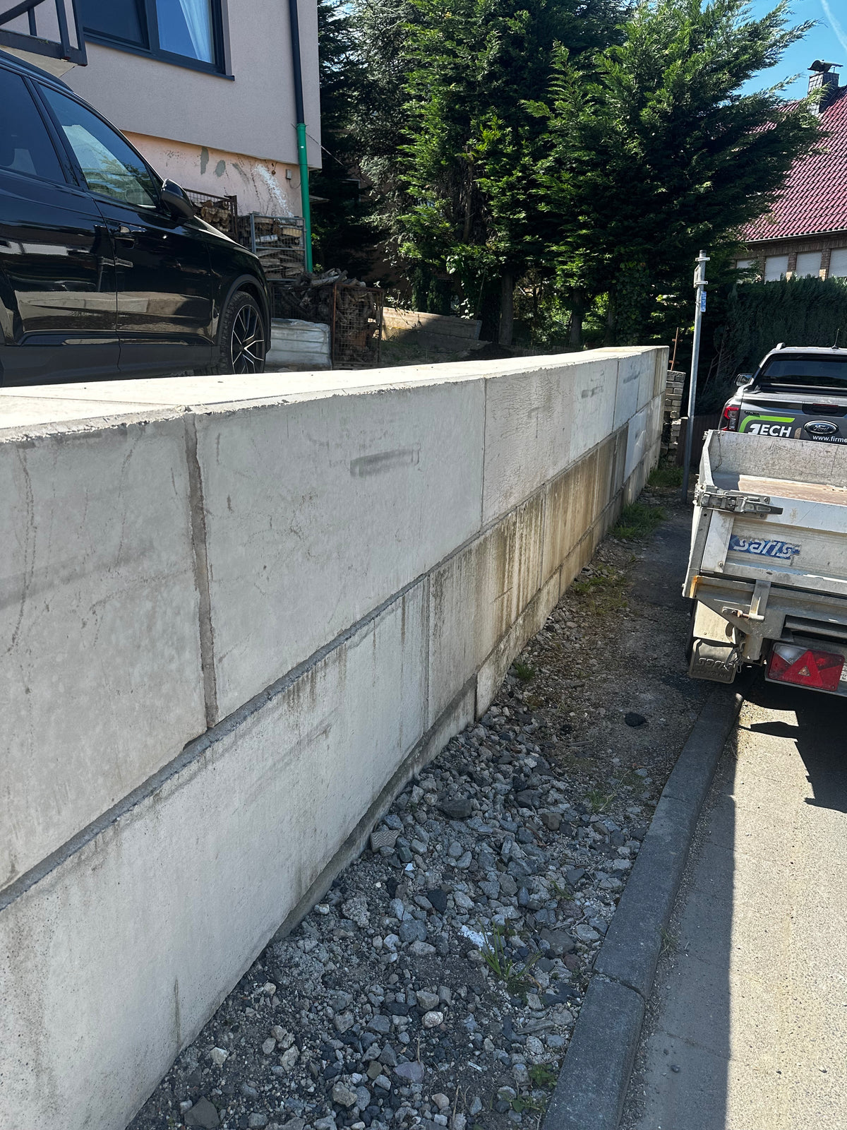 Stützmauer aus Beton Legosteinen an einer Einfahrt mit Kiesfläche