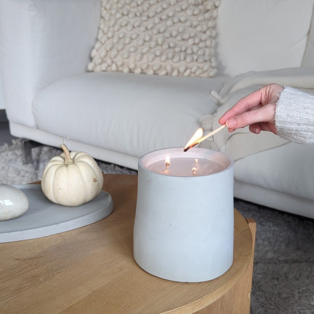 Manubeton Dauerkerze mit dünnem Docht, stilvolle Kerze in Innenraum, warmes Licht und modernes Design.