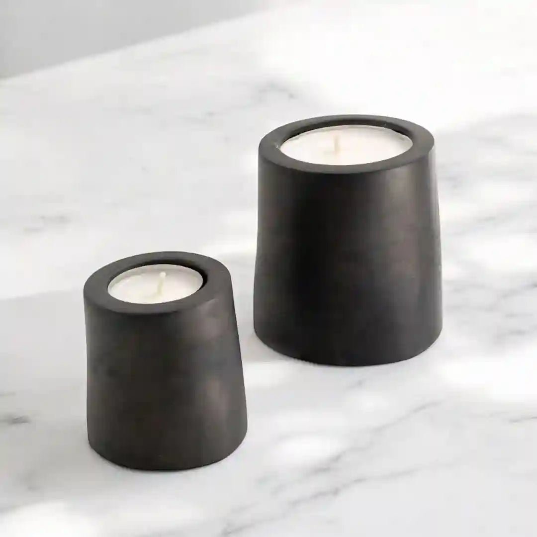 Zwei dunkle Teelichthalter GEMMA von Manubeton aus Beton, modern und stilvoll für Kerzenlicht.
